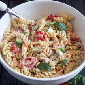 Pasta salad in a white bowl.