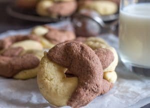 abbracci cookie leaning again 2 stacked with a glass of milk