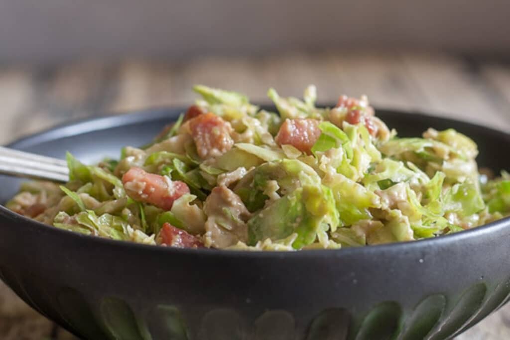 Brussels sprout salad in a black bowl.