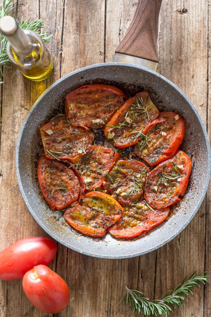 Fried tomatoes in a frying pan.