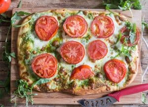 pesto pizza on a wooden board