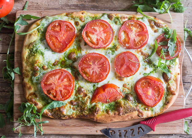 pesto pizza on a wooden board