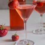 Strawberry liqueur in a bottle and two glasses.