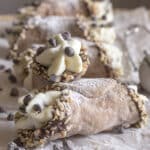 Two cannoli on parchment paper.