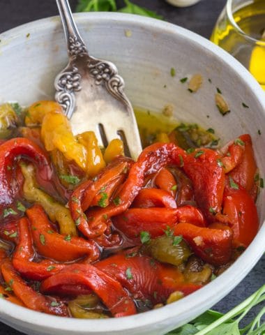 a fork in the white bowl with roasted peppers