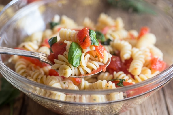 fresh tomato pasta salad in a glass bowl