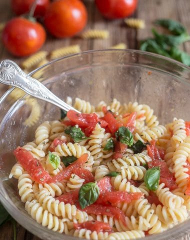fresh tomato pasta salad in a glass bowl