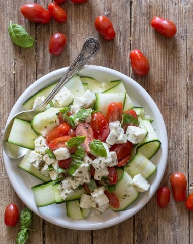 zucchini caprese salad on a white plate
