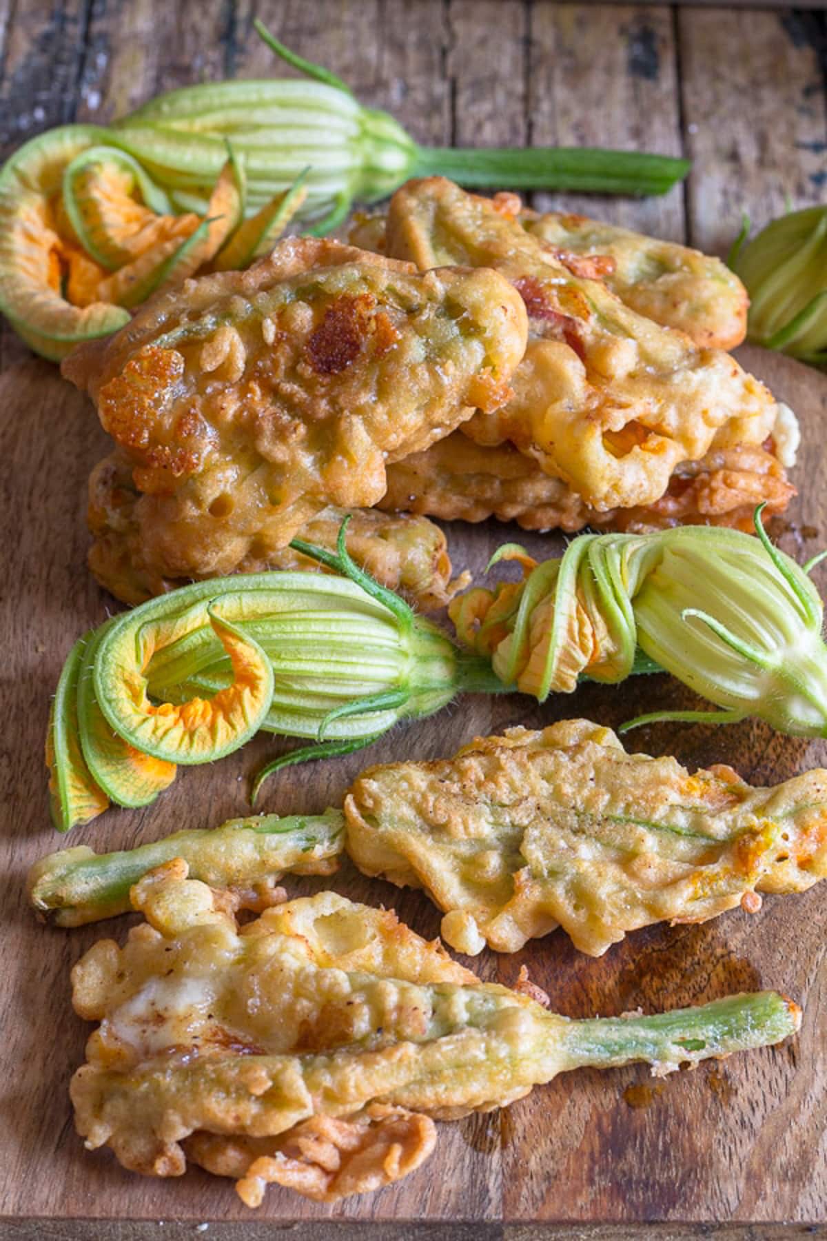 Zucchini stuffed flowers on a wooden board.