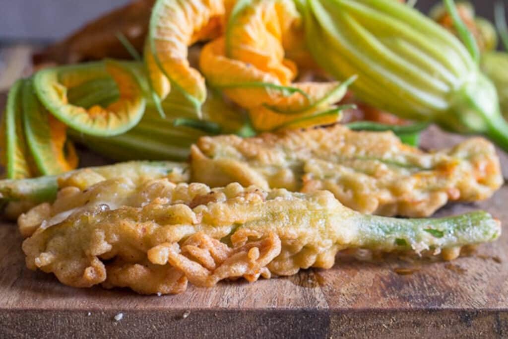 Zucchini flowers on a wooden board.