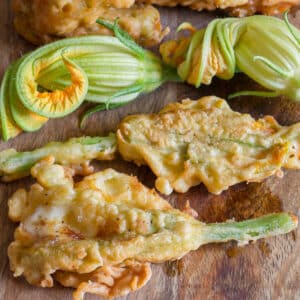 Zucchini stuffed flowers on a wooden board.