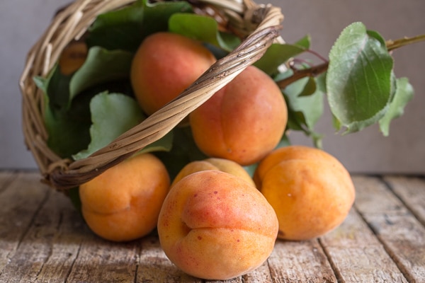 apricots falling out of a basket