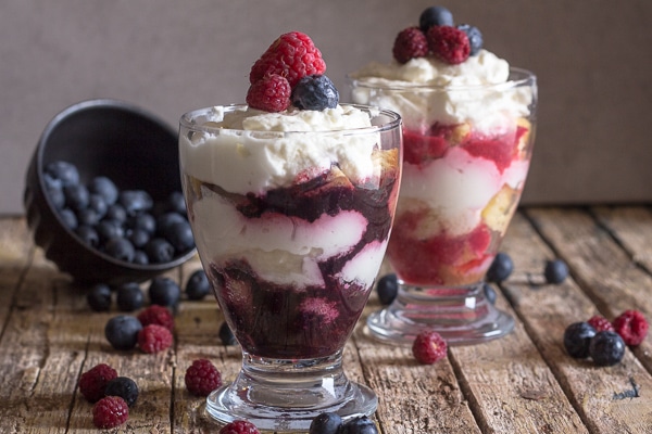 cheesecake parfaits in 2 glasses with fresh berries on top