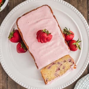 Strawberry bread on a white plate and a slice on the plate.