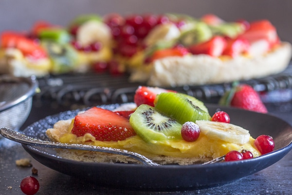 a slice of fruit pizza on a black plate