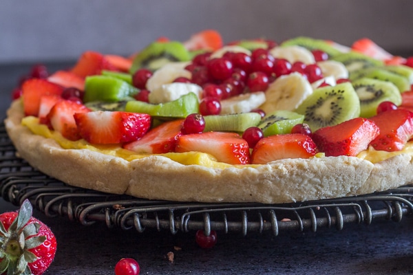 fruit pizza recipe up close on a black wire rack