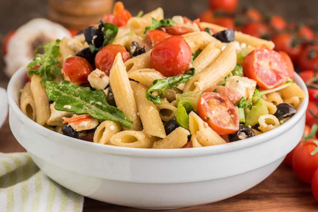 Pasta salad in a white bowl.