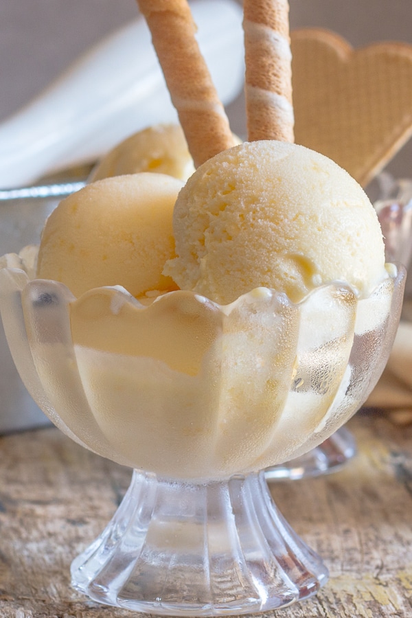 peach ice cream 2 scoops in a glass bowl