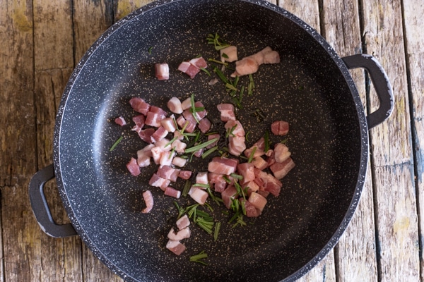 chopped pancetta, oil & rosemary in a black pan