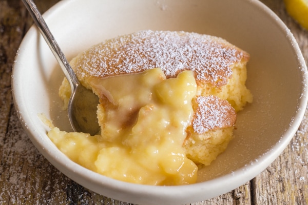 up close lemon pudding cake in a white bowl