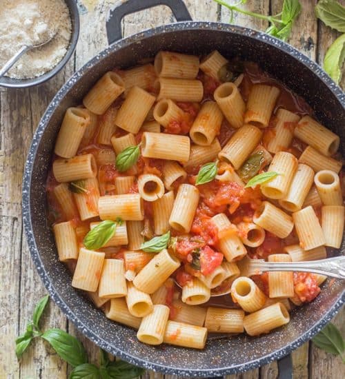 Fresh tomato sauce and pasta in a black pan.