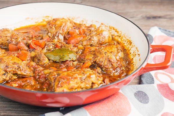 chicken cacciatore in a red and white skillet