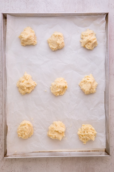 ricotta cookie on a parchment paper lined cookie sheet ready for baking