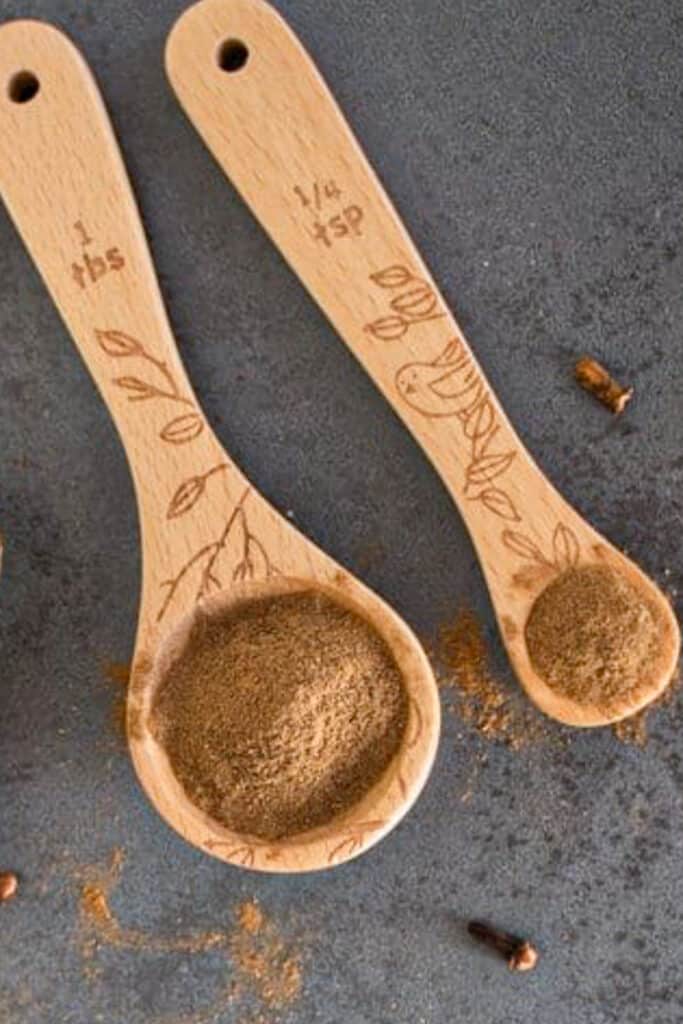 Homemade allspice on two wooden spoons.