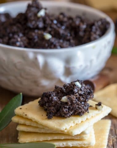 black olive tapenade in a bowl and on a cracker