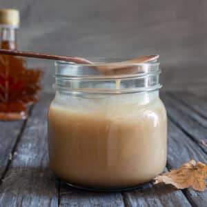 Maple caramel sauce on a spoon and in a jar.