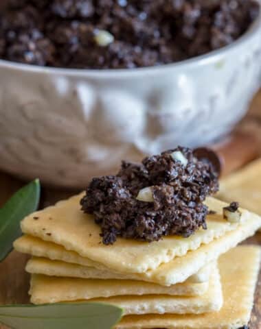 Olive tapenade on crackers and in a bowl.