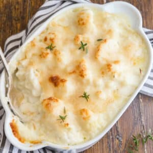 The casserole in a baking pan with a silver spoon.