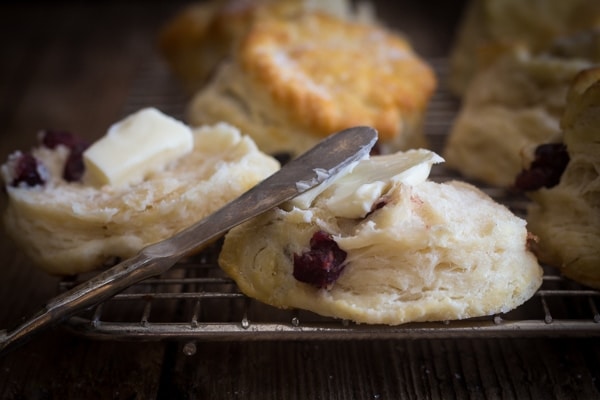 spreading butter on a cranberry scone