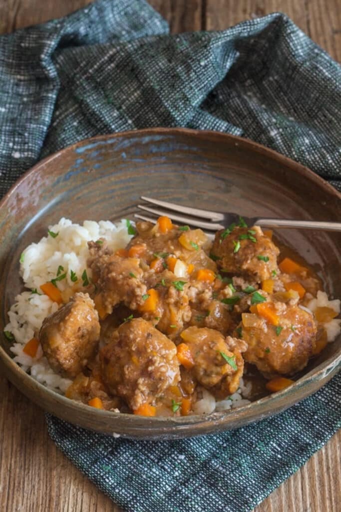 Garlic meatballs and rice in a brown bowl.