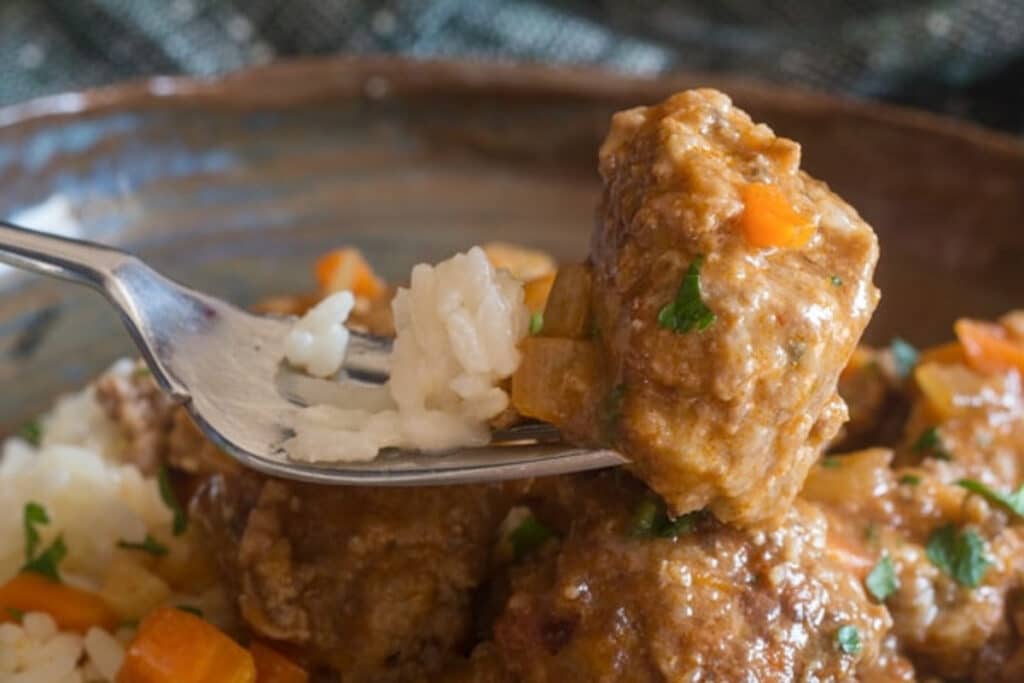 Meatball and rice on a fork.