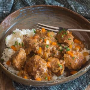 Garlic meatballs and rice in a brown bowl.