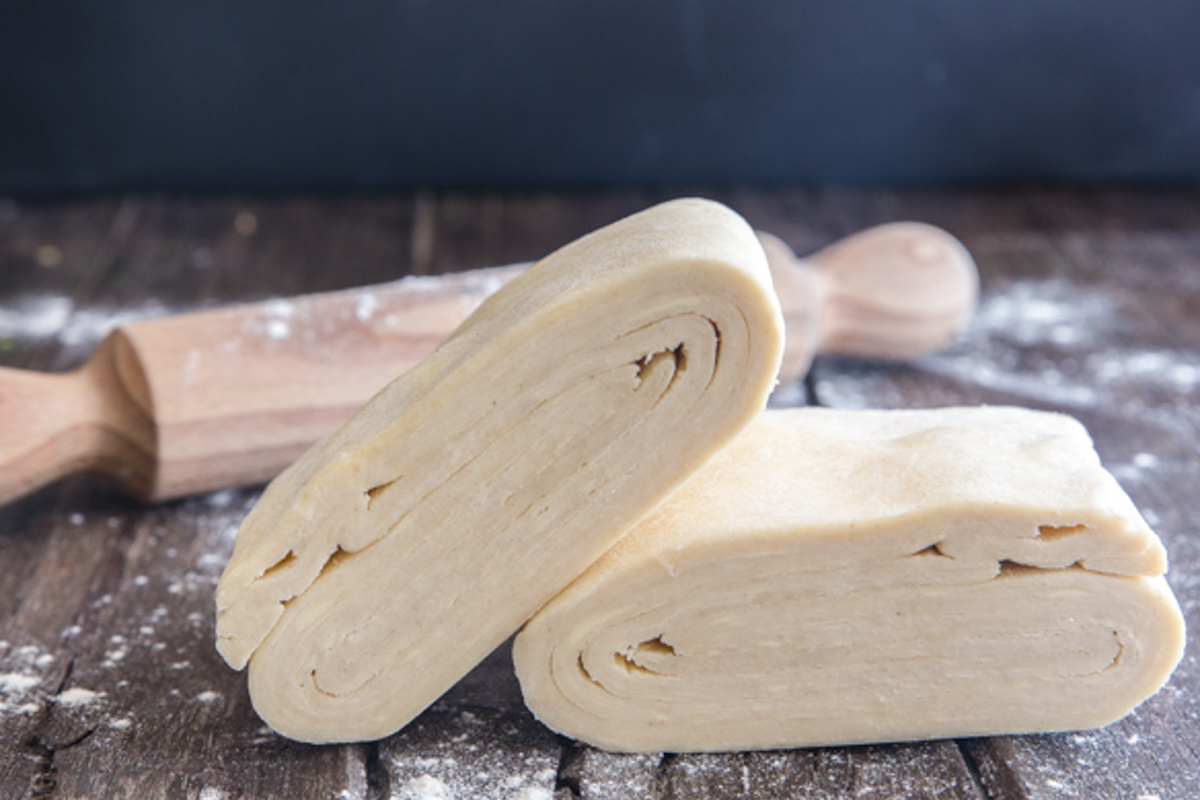 Puff pastry stacked on a wooden board.