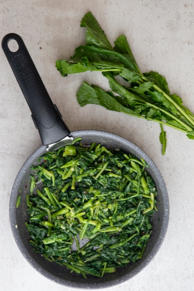 Broccoli rabe in a frying pan.