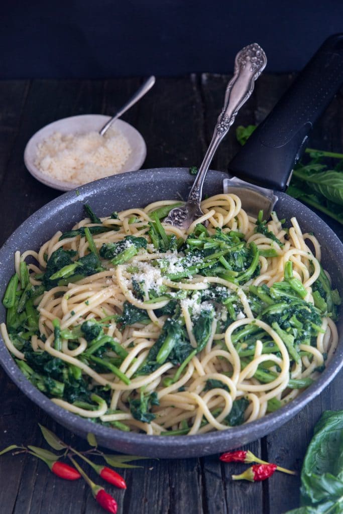 Cooked pasta & broccoli rabe in a black pan.