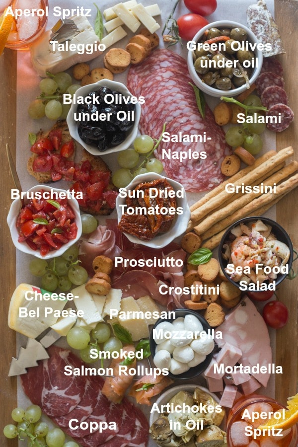all the ingredients written for an antipasto cheese board