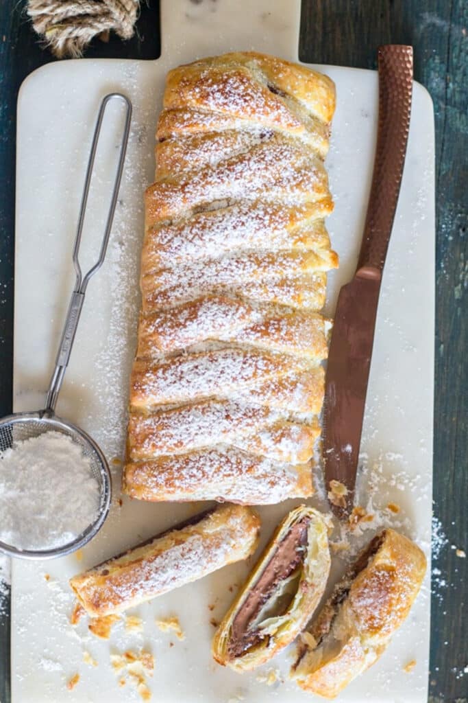 Chocolate pastry braid with three slices cut.
