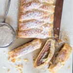 Chocolate pastry braid with three slices cut.
