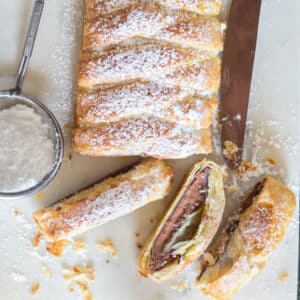 Chocolate pastry braid with three slices cut.