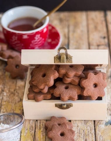 chocolate canestrelli cookies in a wooden box with a cup of tea