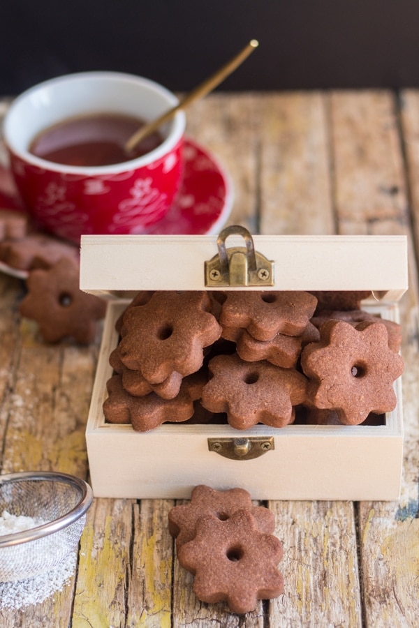 chocolate canestrelli cookies in a wooden box with a cup of tea