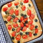 Pugliese focaccia in a baking pan.