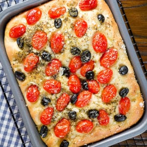 Pugliese focaccia in a baking pan.