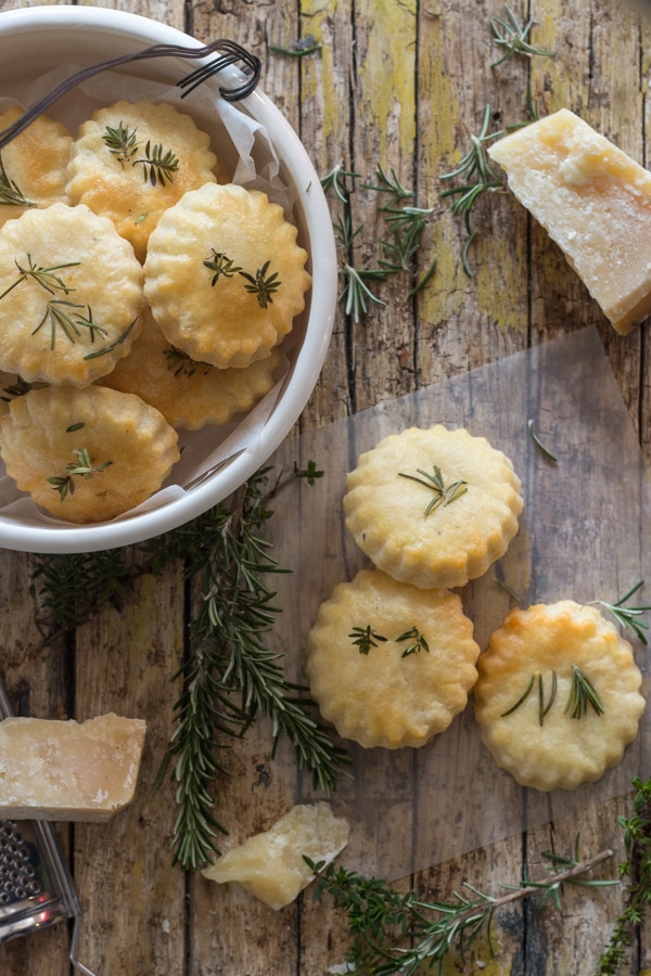 parmesan cookies on a wooden board and in a white bowl