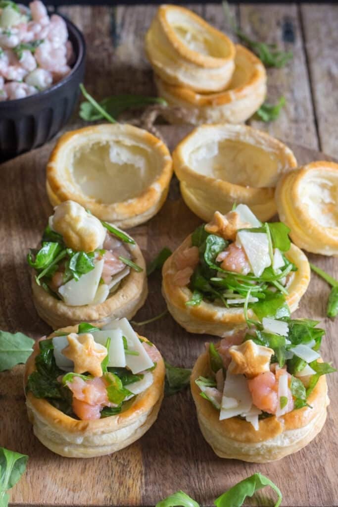 Appetizers filled and empty on a wooden board.