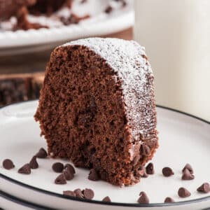 A slice of chocolate bundt cake on a white plate.